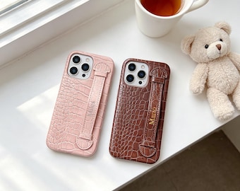 Stylish custom faux crocodile leather textured phone case with convenient wrist strap, compatible with all iPhone models