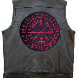 May include: A dark brown leather waistcoat featuring a large circular black patch on the back. The patch displays a red Vegvisir symbol surrounded by a ring of red runic characters. A faint circular logo with the text MOIZ SUPER MART is visible.
