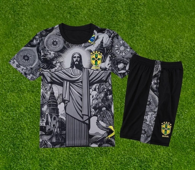 May include: A black and white short-sleeved t-shirt and matching shorts set featuring a graphic print of Christ the Redeemer, intricate patterns, and the yellow and green Brazil national football team crest on both the shirt and shorts.