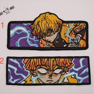 May include: Two rectangular embroidered patches featuring an anime character with yellow hair and a black uniform. The character is surrounded by light blue lightning bolts against a purple background. Each patch has a thick black border.