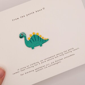 Broderad lapp med grönt stegosaurusmotiv, stryk-på-applikation för babydinosaurier, dekoration för barnjacka och ryggsäck