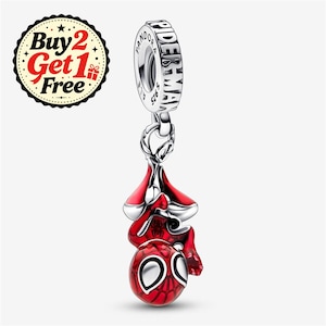 May include: A silver charm featuring a red enameled Spider-Man figure hanging upside down. The cylindrical bail is engraved with the text PANDORA, SPIDER-MAN, and S925. A circular badge in the upper left corner displays the text Buy 2 Get 1 Free.