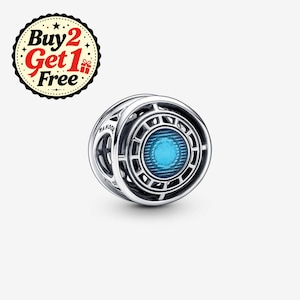 Può includere: Un charm in argento dal design circolare con un centro blu brillante e complessi intagli metallici. Il charm è inciso con la parola Pandora. Un badge circolare nell'angolo mostra il testo Buy 2 Get 1 Free con un'icona a forma di regalo.