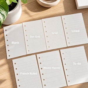 Op de afbeelding: Een set van zes rechthoekige planner-inlegvellen met voorgeponste gaten aan de linkerzijde. De vellen bevatten diverse lay-outs met de labels Blank, Dot Grid, Grid, Lined, French Ruled, Weekly Planner en To-do met selectievakjes.