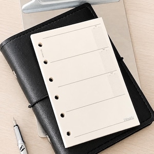 May include: A cream-colored weekly planner refill page with six punched holes along the left side. The page features horizontal lines for writing, labeled sections for days of the week, and the word Weekly printed in the bottom right corner.