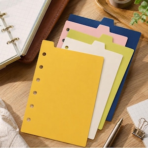 May include: A set of five rectangular planner dividers with tabs, featuring a six-hole punch along the left edge. The dividers are colored yellow, off-white, lime green, light pink, and dark blue, arranged in a cascading stack for organization.