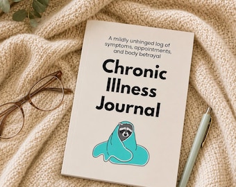 May include: A white journal with the text A mildly unhinged log of symptoms, appointments, and body betrayal and Chronic Illness Journal, featuring a graphic of a raccoon wrapped in a teal blanket, accompanied by brown glasses and a light blue pen.