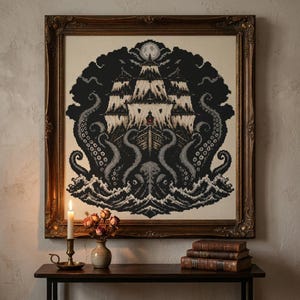 May include: A framed cross-stitch embroidery featuring a large sailing ship surrounded by dark sea waves and giant tentacles. The design is rendered in black, white, and gray tones against a cream background, topped with a full moon in the night sky.