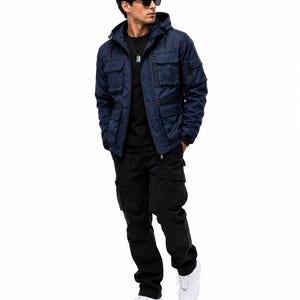 Könnte beinhalten: Eine marineblaue Kapuzenjacke im Utility-Stil mit mehreren Vordertaschen und schwarzen Reißverschlüssen, getragen über einem schlichten schwarzen T-Shirt. Das Outfit umfasst eine schwarze Cargohose und weiße Sneaker, ergänzt durch eine Sonnenbrille.