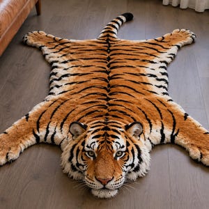 Puede incluir: Una alfombra de felpa con forma de tigre que presenta un patrón realista de rayas naranjas, negras y blancas. La alfombra está diseñada con la forma de un tigre de cuerpo entero con una cabeza detallada, cuatro patas extendidas y una cola larga.
