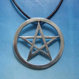 Può includere: Una collana con un ciondolo in argento a forma di pentagramma. Il ciondolo è rotondo e ha un cordino in pelle nera.