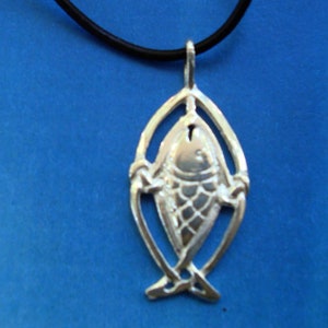 May include: A silver pendant necklace featuring a fish design. The fish is in a Celtic knot design and is on a black leather cord.