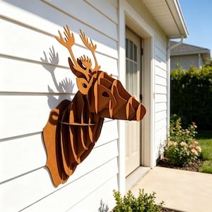 Könnte beinhalten: Eine dreidimensionale Wandskulptur in Form eines Hirschkopfes, gefertigt aus ineinandergreifenden, flachen braunen Platten. Das geometrische Design zeigt die stilisierte Silhouette eines Hirsches mit markantem Geweih in Schichtoptik.