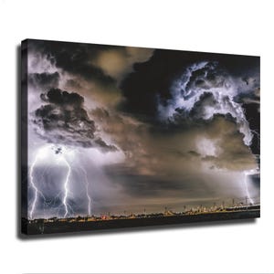 Puede incluir: Un lienzo rectangular que muestra un paisaje nocturno dramático con nubes de tormenta oscuras y densas. Relámpagos blancos brillantes caen hacia una línea de horizonte distante y tenuemente iluminada con siluetas de árboles y postes.