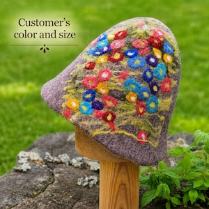 May include: A felted hat in a muted purple hue featuring a vibrant, multi-colored floral pattern of red, blue, yellow, and orange circles with green accents. The text "Customer's color and size" is printed in dark brown on the upper left side.