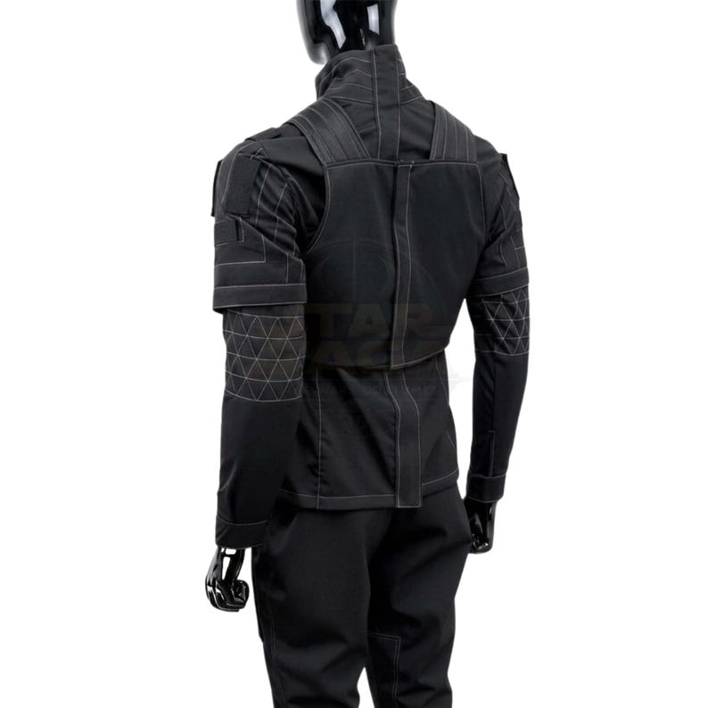 Puede incluir: Una chaqueta t&aacute;ctica negra y pantalones a juego sobre un maniqu&iacute;. La chaqueta presenta un cuello alto, paneles estructurados en los hombros y patrones de costura geom&eacute;trica blanca en las mangas y la espalda. El dise&ntilde;o incluye costuras verticales.