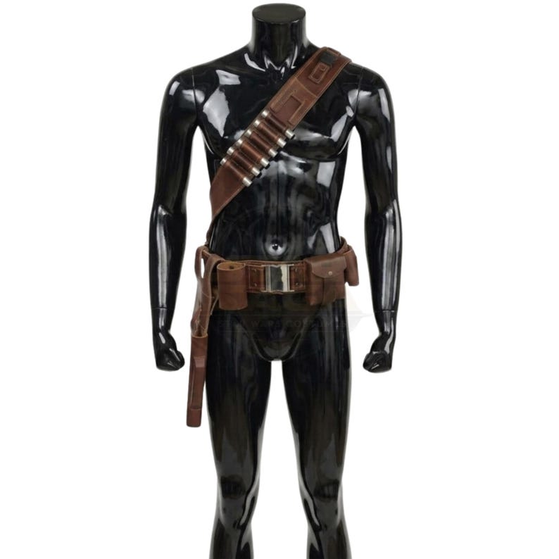 May include: A brown leather bandolier and utility belt set featuring a diagonal shoulder strap with silver-toned cylindrical cartridge holders, a central metallic buckle, two attached rectangular pouches, and a long holster on the right side.