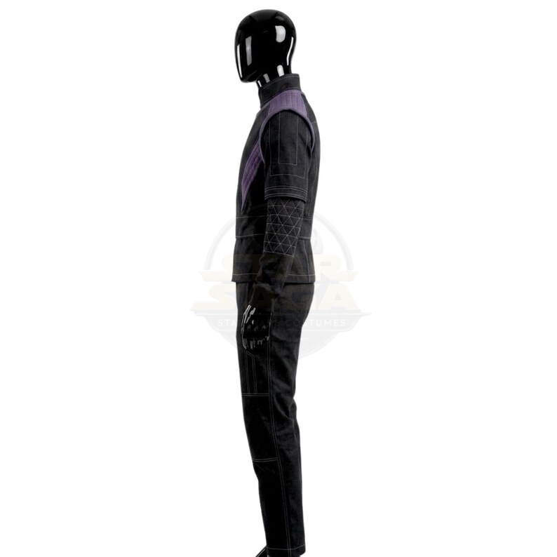 May include: A black costume set featuring a high-neck jacket with purple shoulder accents and a geometric quilted pattern on the sleeves. The matching black trousers include visible white stitching details along the legs and a structured silhouette.