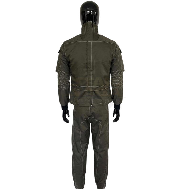 May include: A dark olive green two-piece uniform set featuring a high-collar jacket with white contrast stitching, short sleeves with geometric patterned panels, and matching long trousers. The jacket includes a central vertical zipper closure.
