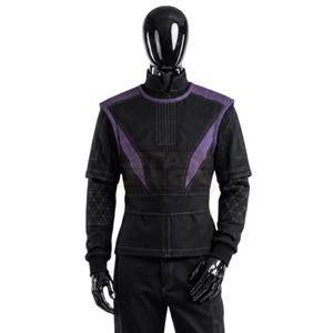 May include: A black long-sleeved jacket with a high collar and a front zipper closure. The garment features purple panels on the shoulders and chest, with a geometric triangle pattern stitched onto the lower sleeves and visible white stitching.