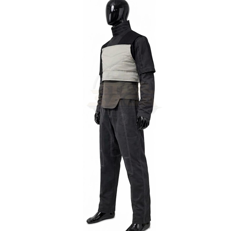May include: A black mannequin wearing a dark grey high-neck shirt with short sleeves, a light grey chest plate with horizontal stitching, a dark grey waist panel, and matching dark grey trousers featuring visible white stitching along the seams.