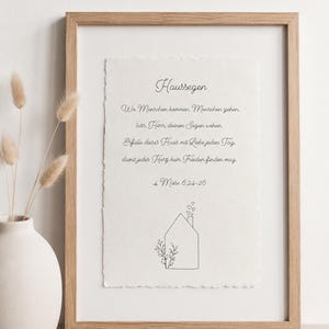 Könnte beinhalten: Ein gerahmter Druck mit dem deutschen Text "Hausegen", gefolgt von einem Segen und der Referenz "4. Mose 6:24-26". Unter dem Text befindet sich eine einfache Strichzeichnung eines Hauses mit einem Schornstein, der Herzen ausstößt.
