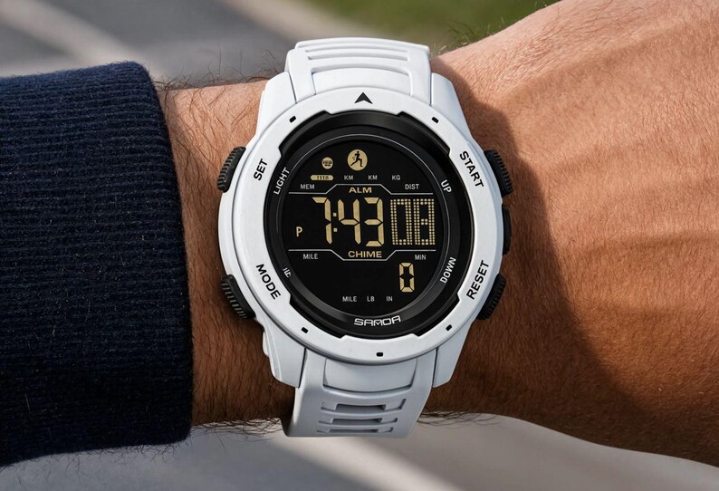 May include: A white digital sports watch with a black circular face and a textured white silicone strap. The display shows the time 7:43, the text SAMOA, ALM, CHIME, and various icons including a runner. It features side buttons labeled SET, LIGHT, START, UP, DOWN, RESET, and MODE.