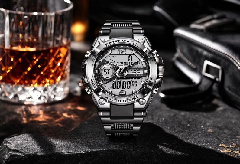 May include: A silver and black analog-digital sport watch with a metallic bezel, black silicone strap, and a multi-functional dial. The watch face features the text SPORT WATCH, LIGE, and WATER RESIST, with digital displays and luminous hands.