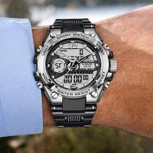 May include: A silver and black analog-digital sport watch with a metallic bezel, featuring the text LIGE, SPORT WATCH, WATER RESIST, LIGHT, START, MOD, and RESET. The watch has a multi-functional dial with digital displays and a black link band.