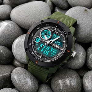 May include: A dual time wristwatch with an olive green textured silicone strap and a black circular bezel. The watch face features a combination of analog hands and a digital display with bright teal accents, displaying the brand name SKMEI.