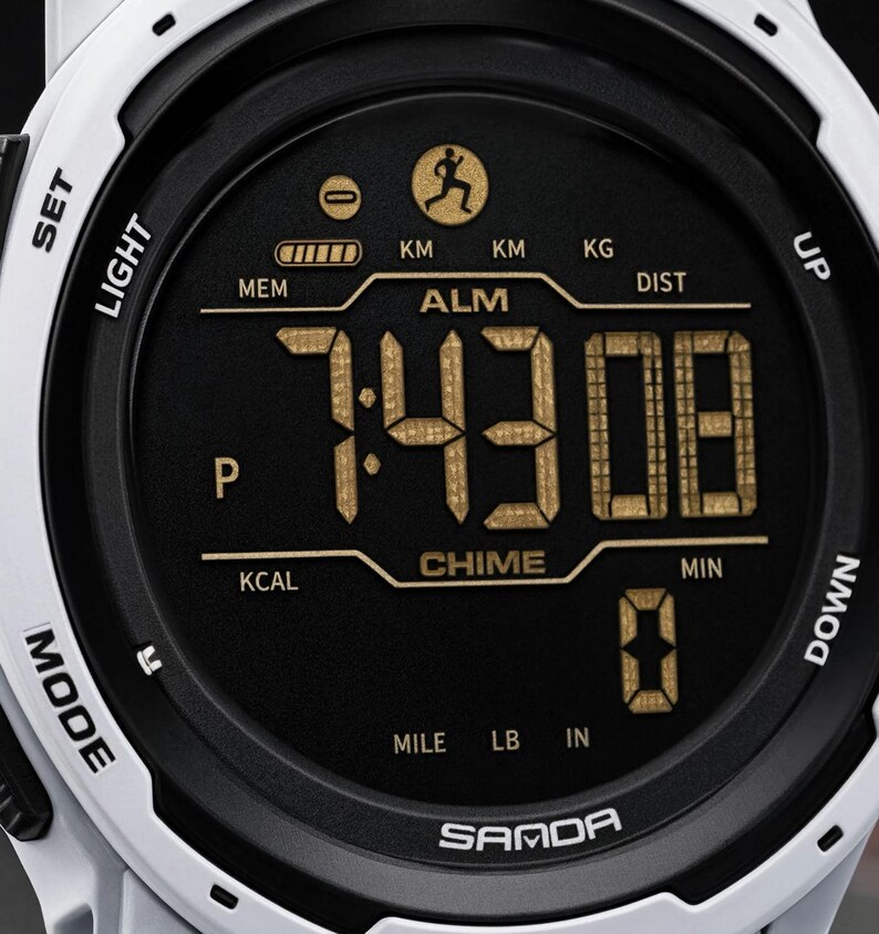 May include: A white digital sports watch with a black circular face featuring gold-colored digital numbers and text. The display shows the time 7:43:08, along with icons for a runner, battery level, and labels including ALM, CHIME, KCAL, DIST, KM, KG, MILE, LB, IN, and SAMDA.