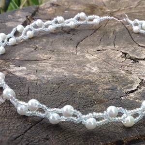 Peut inclure: Un diadème délicat en perles blanches et cristaux, parfait pour un mariage ou une occasion spéciale.