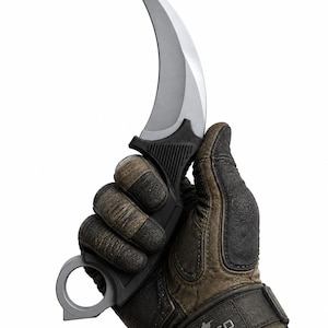 Könnte beinhalten: Ein gebogenes Karambit-Messer mit silberfarbener Klinge und schwarzem, strukturiertem Griff, der an der Basis einen Fingerring aufweist. Der Griff wird von einem dunkelbraunen und schwarzen taktischen Handschuh mit CS:GO-Aufdruck gehalten.