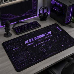 May include: A rectangular black desk mat featuring purple graphic prints of a game controller, a keypad, and circuit board patterns. The text reads ALEX GAMING LAB, LEVEL UP, COLLEGE MODE, CLASS OF 2029, and 2026 in a futuristic font style.