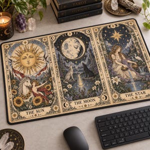 Könnte beinhalten: Eine rechteckige Schreibtischunterlage mit drei Tarotkarten-Illustrationen, beschriftet mit The Sun, The Moon und The Star. Das Feld The Sun zeigt ein Sonnengesicht, ein weißes Pferd und Sonnenblumen. Das Feld The Moon zeigt ein Mondgesicht, Wölfe und einen See. Das Feld The Star zeigt eine Frau, die Wasser gießt.