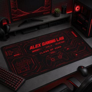 May include: A rectangular black desk mat featuring a red digital circuit board pattern, a game controller graphic, and the text "ALEX GAMING LAB", "LEVEL UP", "COLLEGE MODE", "CLASS OF 2029", and "2026" printed in a bold, futuristic red font.
