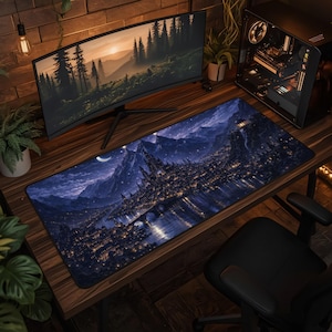 Puede incluir: Una alfombrilla de escritorio rectangular con una escena nocturna detallada de una ciudad fantástica con luces brillantes, un río y montañas bajo un cielo estrellado con una luna creciente. Presenta una paleta de colores azul oscuro y dorado.