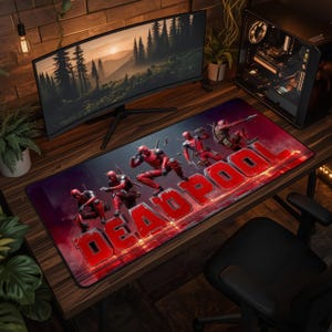 May include: A rectangular desk mat featuring a graphic print of the character Deadpool in various action poses. The design includes the word DEADPOOL in large, bold, red block letters across the bottom, set against a dark, smoky red background.