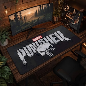 May include: A rectangular black desk mat featuring the white distressed text The Punisher and a large white skull graphic. The Marvel logo is printed in red and white in the upper left corner of the mat. The design has a weathered, grunge aesthetic.