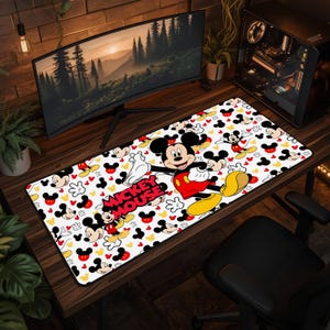 May include: A rectangular desk mat featuring a white background with a repeating pattern of Mickey Mouse heads, gloves, and full-body illustrations. The text MICKEY MOUSE is printed in bold red letters in the center of the mat.