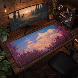 May include: A rectangular desk mat featuring a printed landscape illustration of a vibrant sky with large, golden-lit clouds, a thin crescent moon, and dense clusters of bright pink flowers in the foreground, set against a dark blue sky.