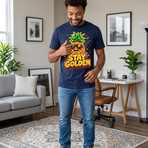 Peut inclure: Un t-shirt bleu marine à manches courtes orné d'un motif d'ananas souriant portant des lunettes de soleil avec le texte STAY GOLDEN en lettres jaunes, associé à un jean bleu et des baskets bleu marine, blanches et dorées.