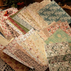 Peut inclure: Une collection de feuilles de papier décoratives présentant une variété de motifs floraux, botaniques et damassés dans des tons de vert sauge, crème, beige, rouge et marron. L'assortiment comprend diverses textures et motifs imprimés.