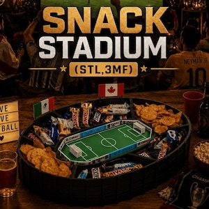 May include: A black, oval-shaped snack stadium serving tray featuring a central miniature soccer field model, divided compartments for various snacks, and small flags including Canada and Mexico, with the text SNACK STADIUM (STL,3MF).