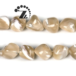 May include: Two strands of polished, irregular-shaped beads. The beads are a mix of tan and white, with a pearlescent sheen. The beads are strung together, likely for jewelry making. The logo "Z" is in the top left corner.