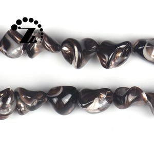 May include: Two strands of heart-shaped beads in shades of brown and gray. The beads have a glossy finish and are strung together. The beads are on a white background. The beads are approximately 1 cm in size.