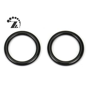 Pode incluir: Dois anéis de metal preto, cada um com um diâmetro de aproximadamente 3,8 cm.