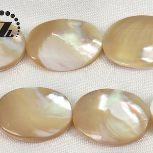May include: A strand of oval-shaped, iridescent, beige mother-of-pearl beads.
