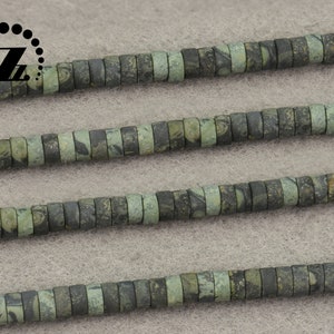 May include: Strands of flat, disc-shaped beads in shades of green and gray. The beads have a mottled pattern, creating a natural, earthy appearance. The beads are strung together, suitable for jewelry making or crafting projects.