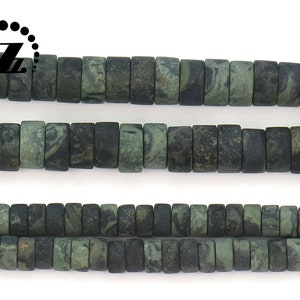 May include: Strands of dark green and black rectangular beads. The beads have a marbled appearance, with variations in color and texture. The beads are strung together, creating a necklace or bracelet.